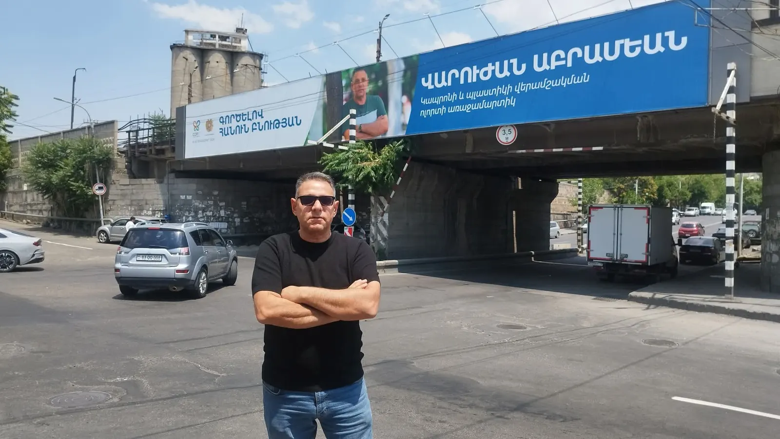 Varodjan Abramian standing in front of his recycling billboard in Yerevan